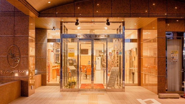 The entrance to a hotel with a glass door, a reception desk, and a tiled floor. - Toyoko Inn Asahikawa Ekimae Ichijo-dori (HOKKAIDO)