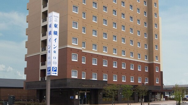 A multi-story hotel with a prominent signage for 'Toyoko Inn' and a visible parking sign indicating a P parking area. - Toyoko Inn Hokkaido Asahikawa-eki Higashi-guchi (HOKKAIDO)