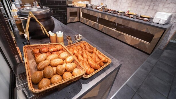 A buffet area with bread and pastries.
