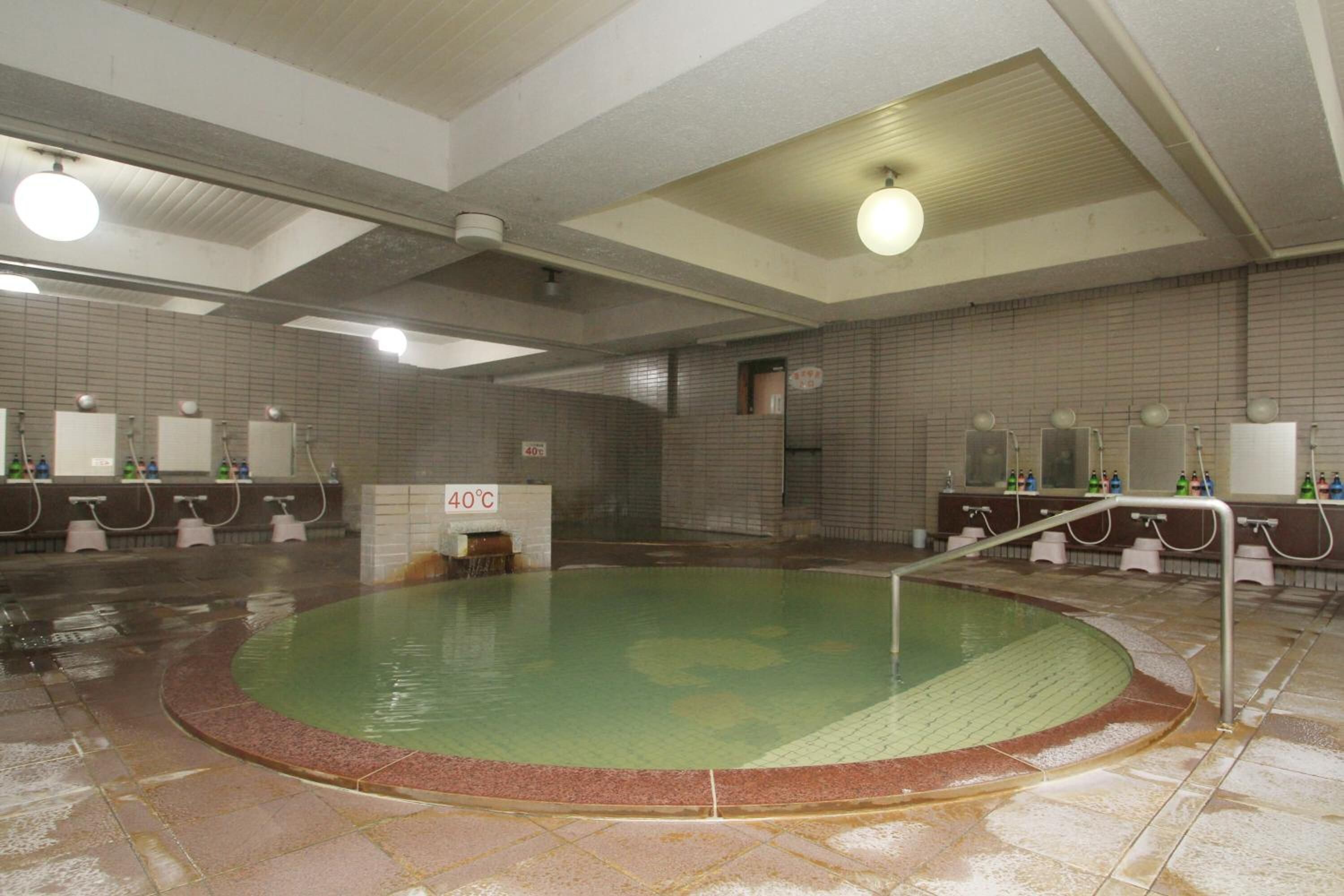 Una gran piscina cubierta con un cartel que indica una temperatura de 40°C.