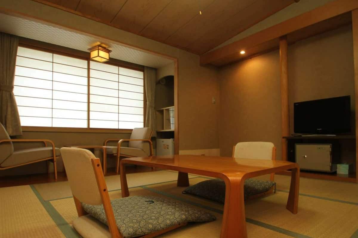 Ett traditionellt japanskt rum med tatamimattor på golvet, ett lågt träbord och sittplatser bestående av tatamimattor.
