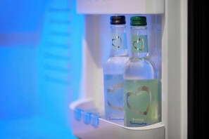A refrigerator with two bottles of water and a bottle of juice. - Premier Inn London City (Aldgate) (London)