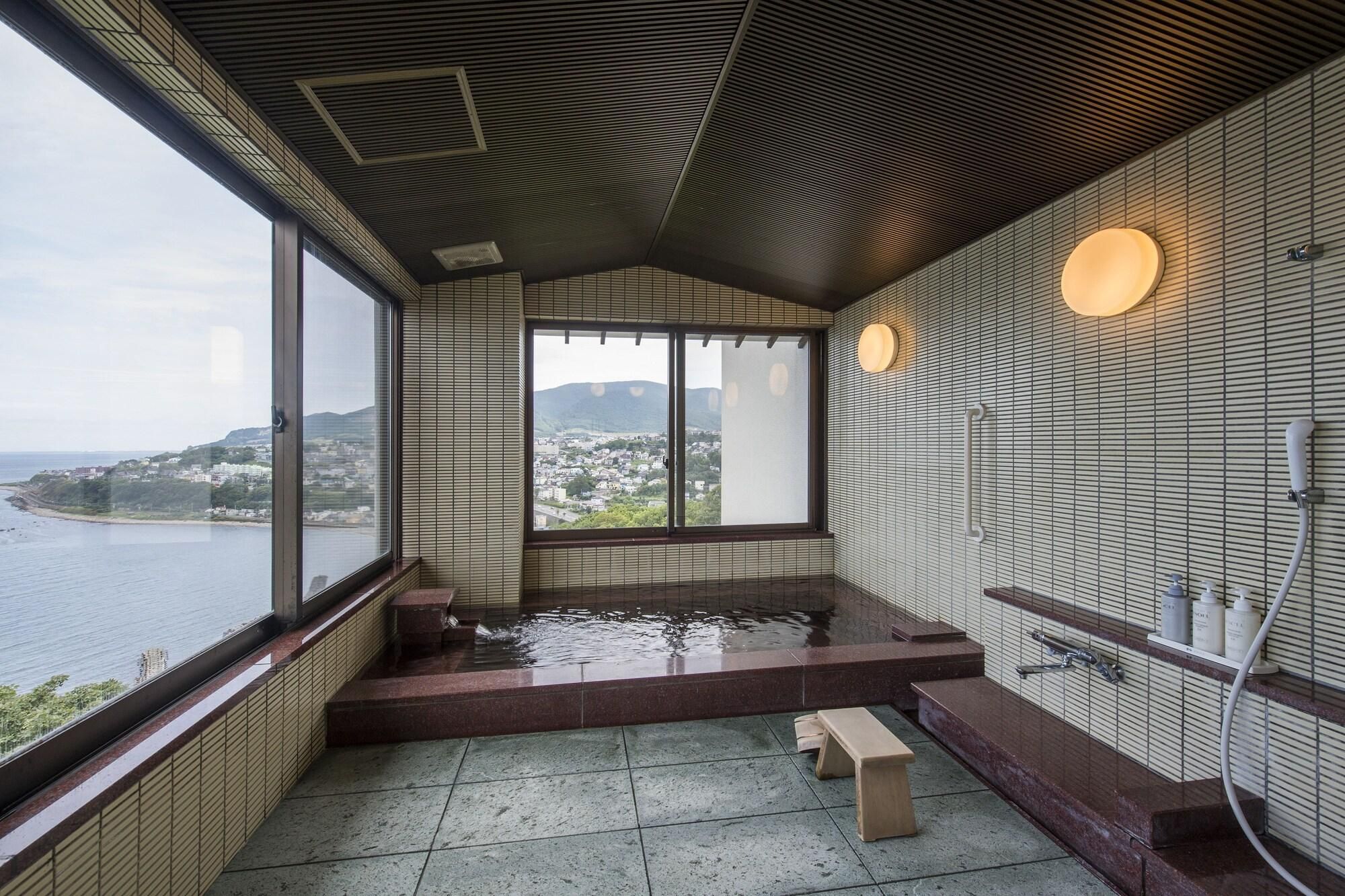 Casa de banho moderna com uma janela ampla, banheira e área de chuveiro.