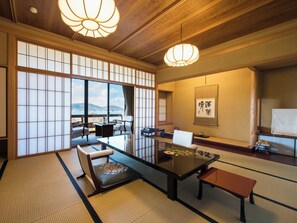 A traditional Japanese room with tatami flooring, a low table, seating, and a view through shoji screens. - Ginrinsou (Otaru)