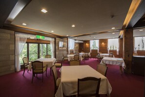 A restaurant with tables and chairs, large windows, and a red carpet. - Ginrinsou (Otaru)