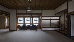 A traditional Japanese room with tatami flooring, a low ceiling, and sliding doors. - Ginrinsou (Otaru)