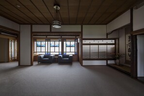 A traditional Japanese room with tatami flooring, a low ceiling, and sliding doors. - Ginrinsou (Otaru)
