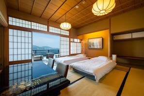 A traditional Japanese-style room with tatami flooring, a low wooden ceiling, and a balcony with a view. - Ginrinsou (Otaru)