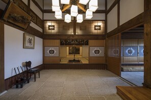 A traditional Japanese room with tatami flooring, a low wooden table, and a hanging light fixture. - Ginrinsou (Otaru)