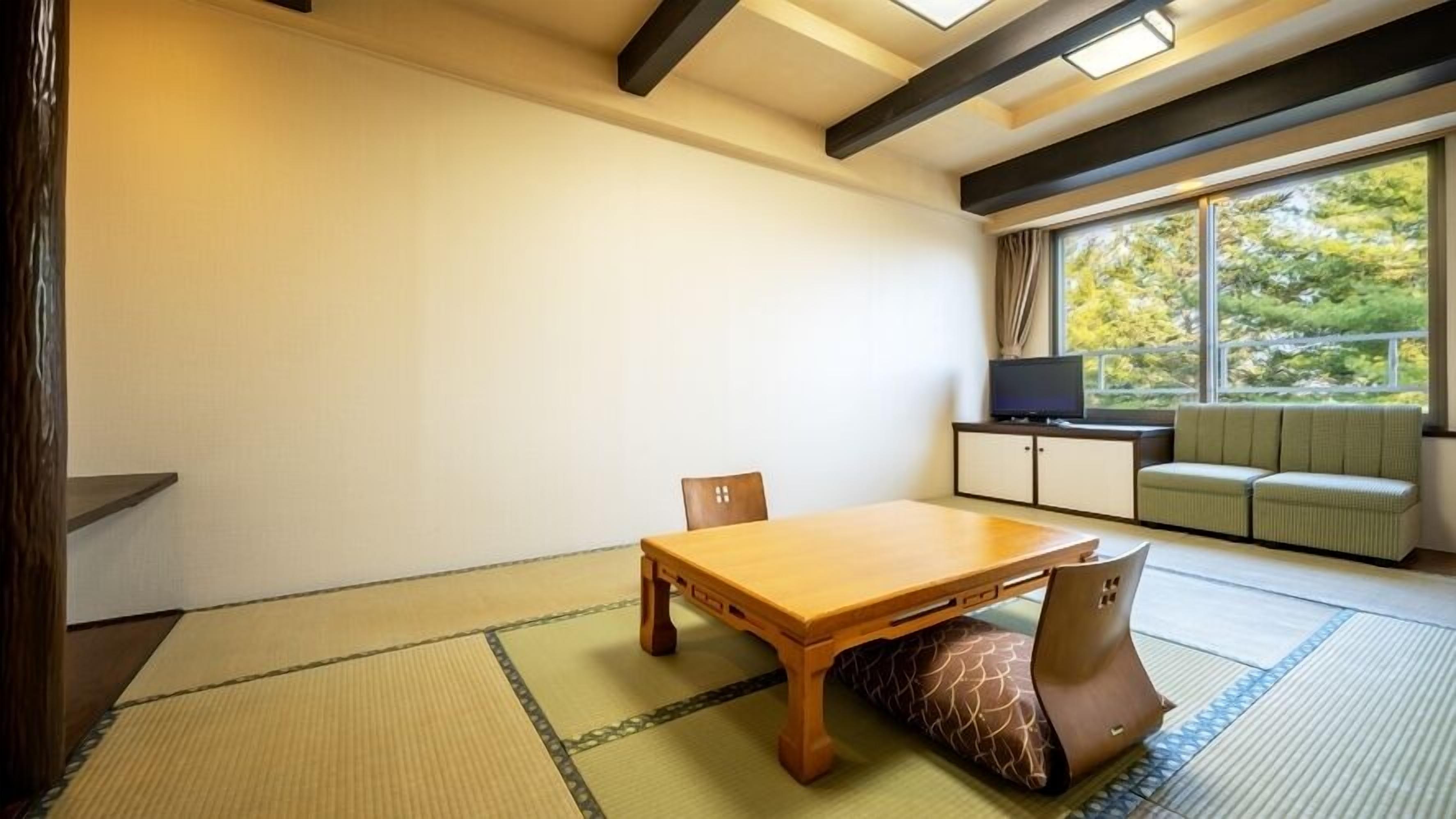 A traditional Japanese room with tatami flooring, a low wooden table, and a sofa by a window.