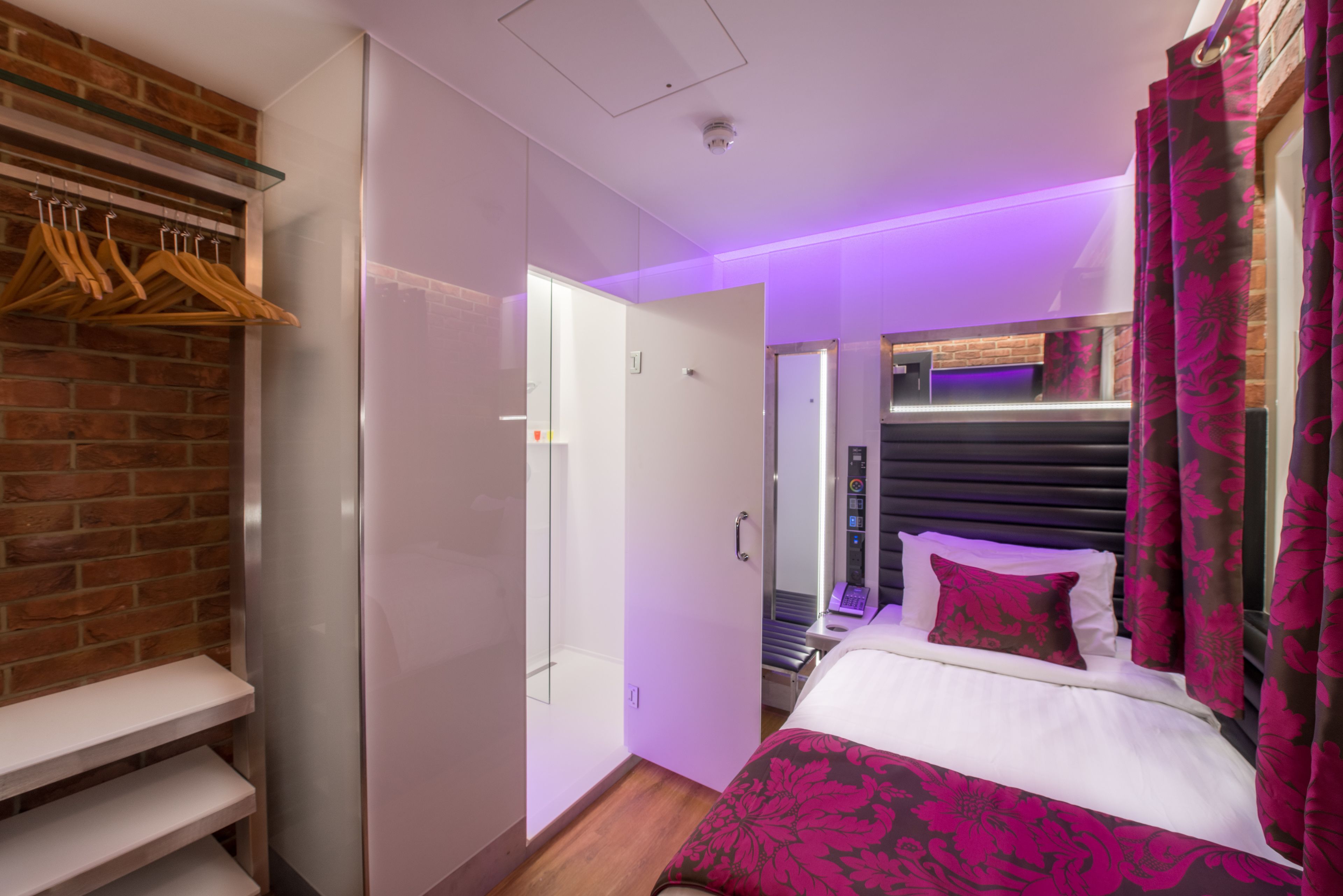 A hotel room with a bed, a wardrobe, and a bathroom.