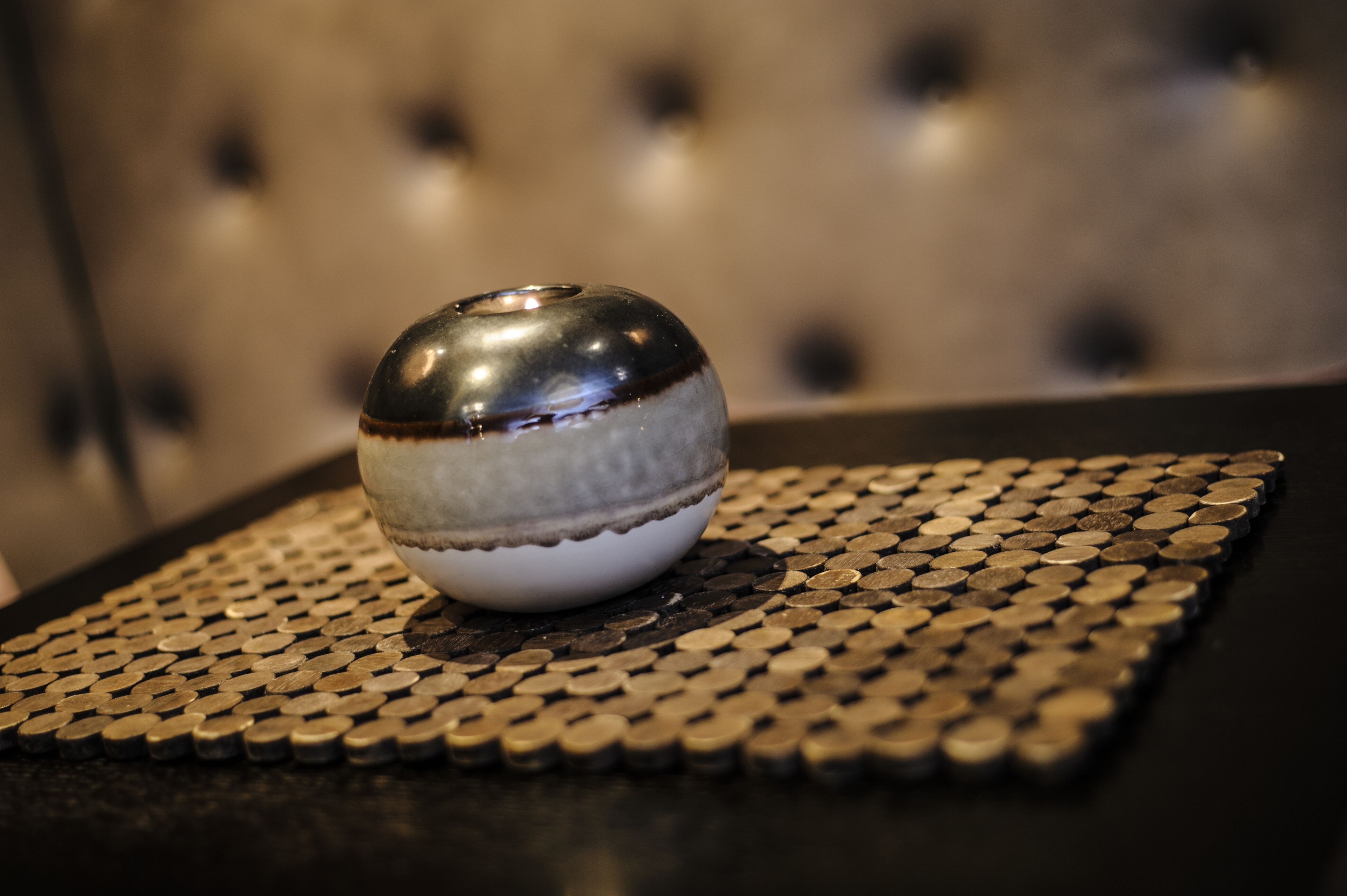 A metallic spherical object on a textured surface.