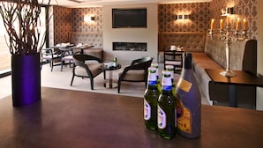 Une chambre d’hôtel comprenant un coin repas, un canapé et un téléviseur fixé au mur.