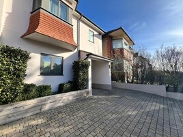 A modern two-story house with a paved driveway and a covered porch.