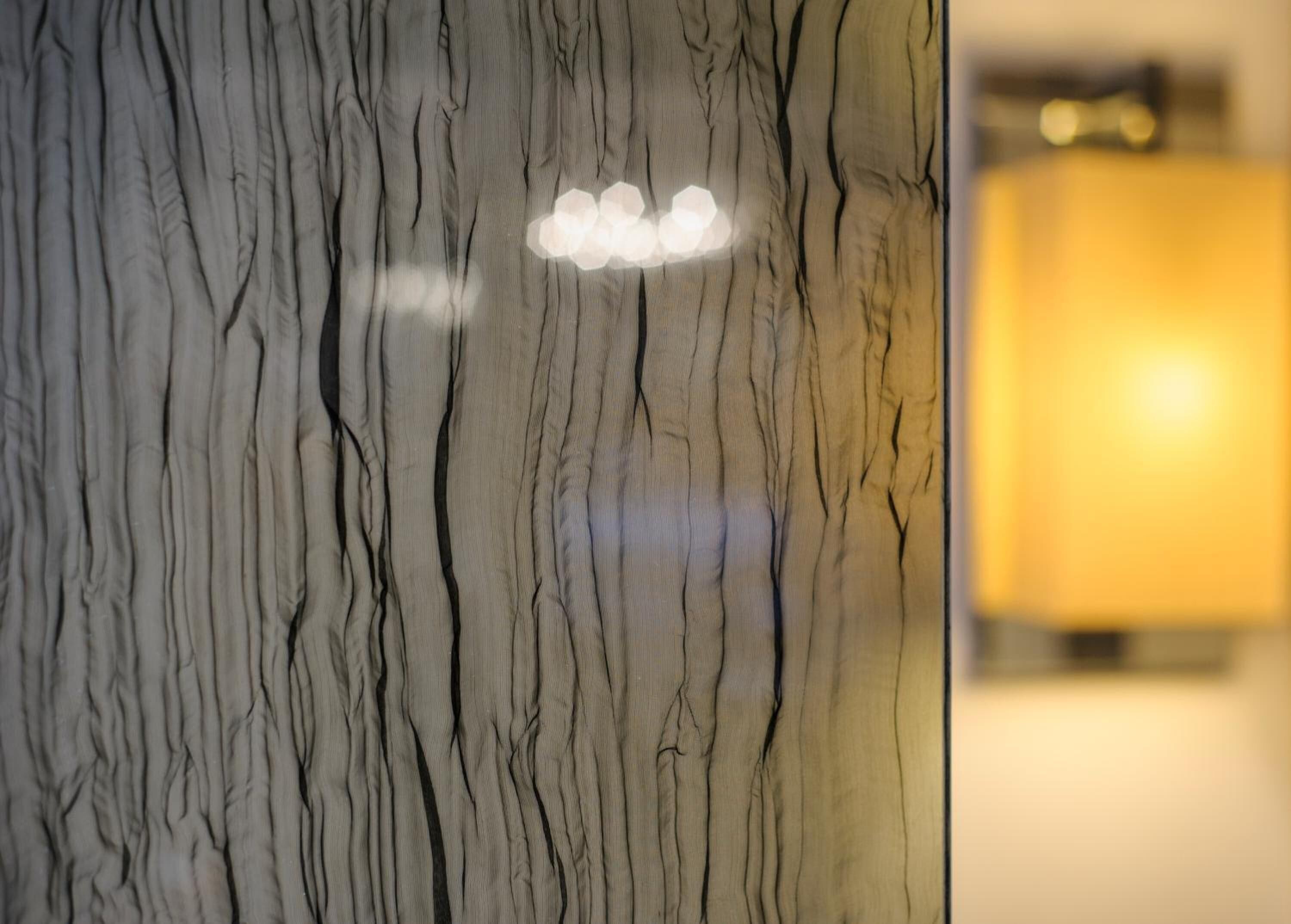 A marble wall with a light fixture and a blurred background.