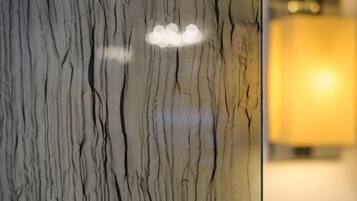 A marble wall with a light fixture and a blurred background.