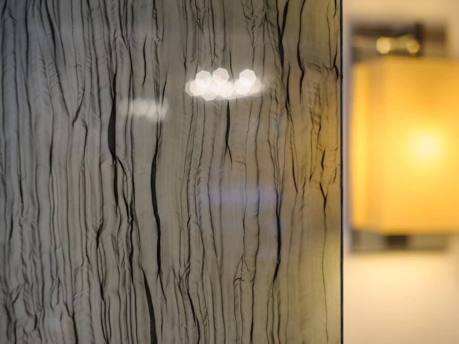 A marble wall with a light fixture and a blurred background.