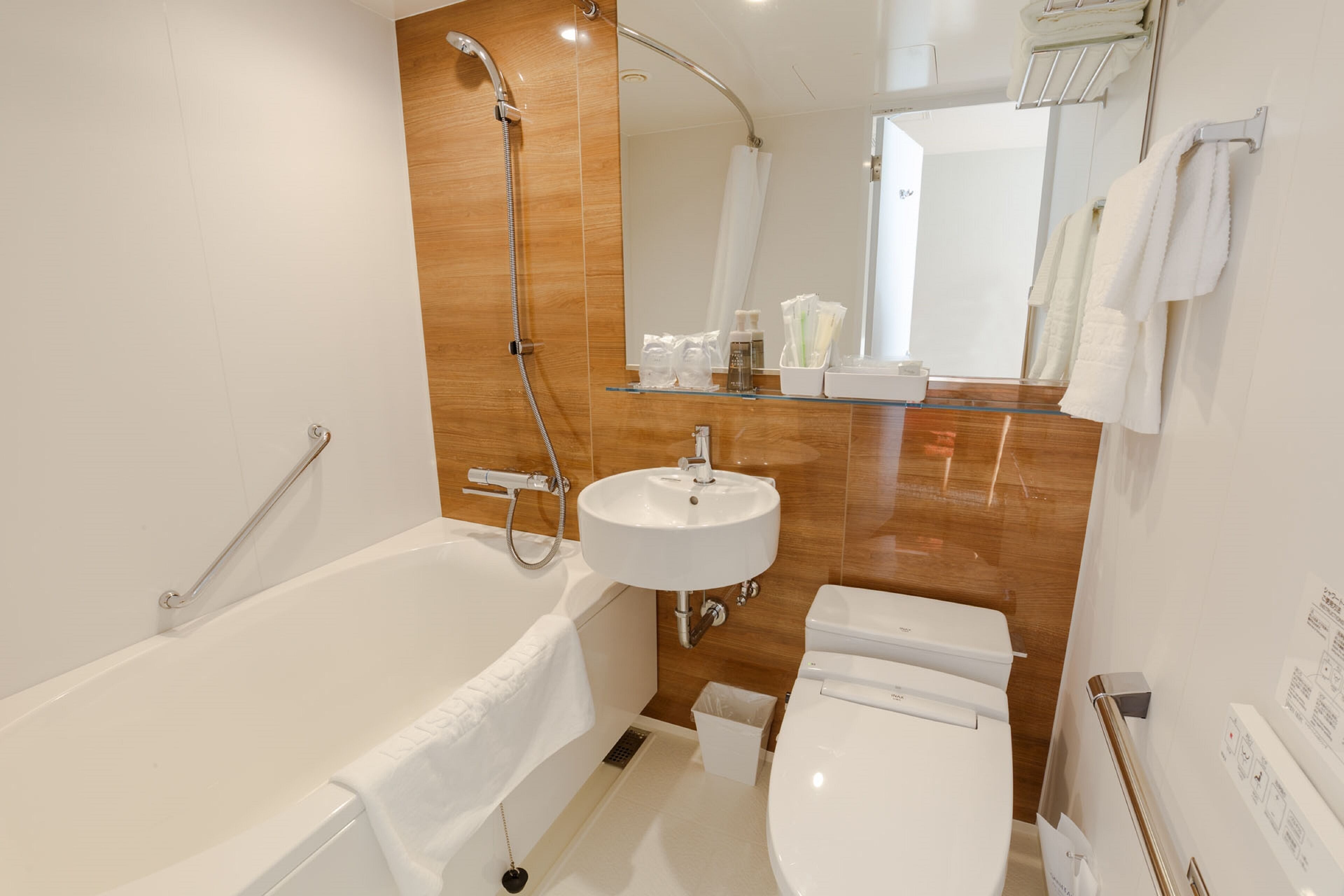 A modern bathroom with a bathtub, a sink, and a toilet.