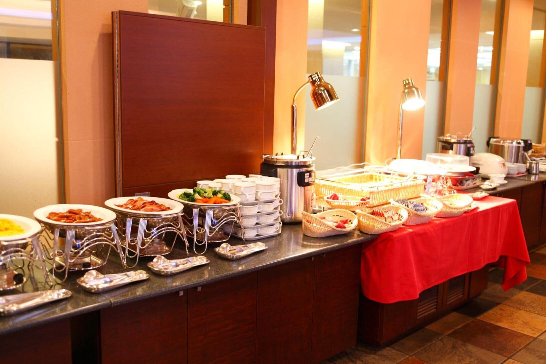 A buffet setup with various food items and serving utensils.