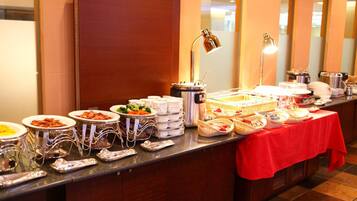 A buffet setup with various food items and serving utensils.