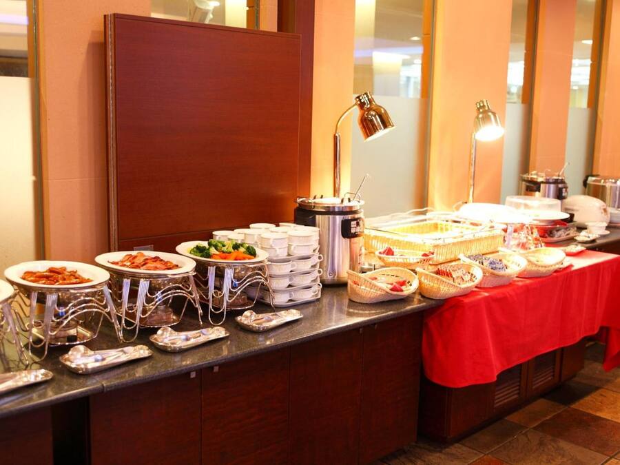 A buffet setup with various food items and serving utensils.