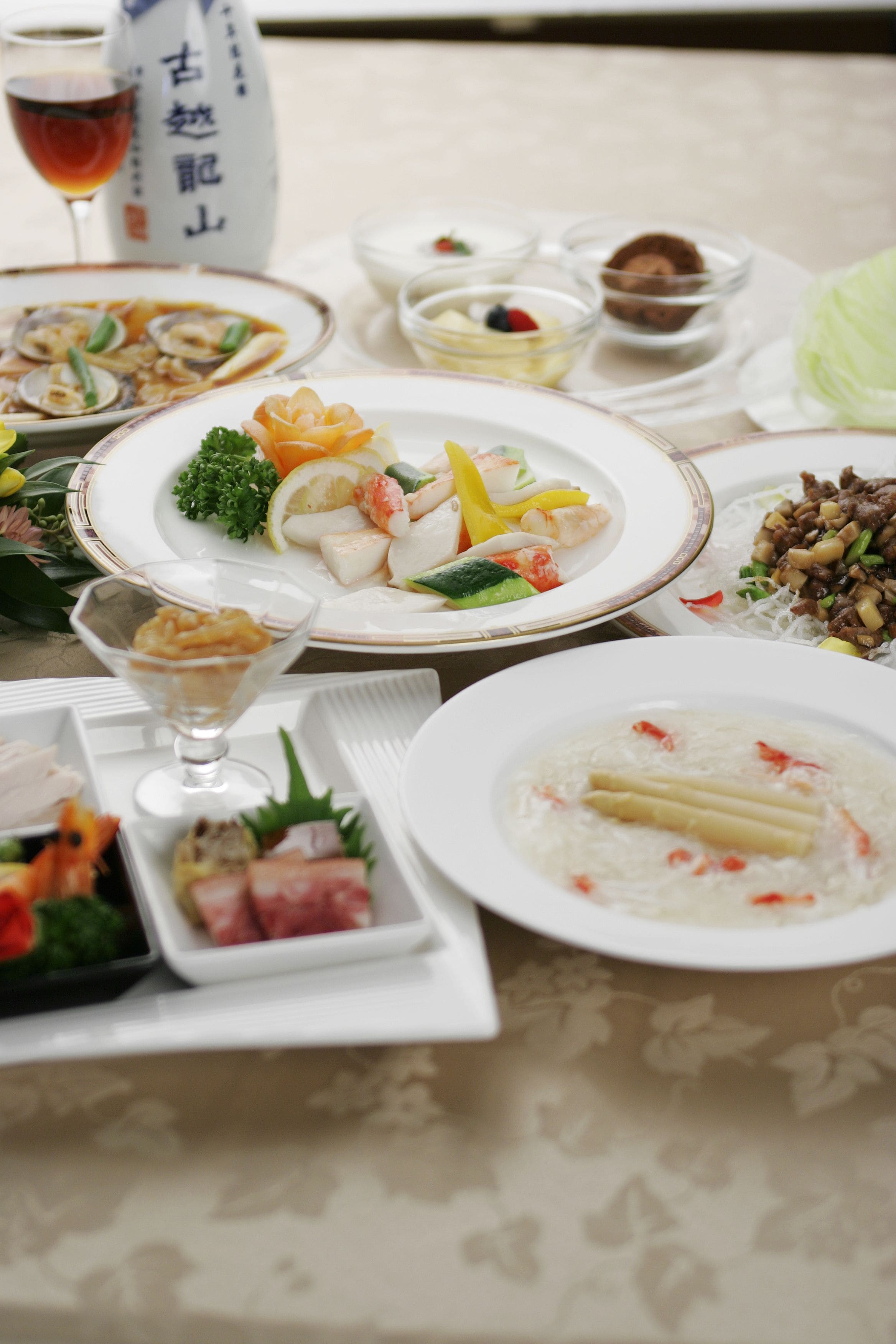 A table set with various dishes, including seafood, vegetables, and a dessert.