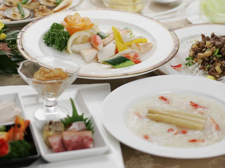 A table set with various dishes, including seafood, vegetables, and a dessert.