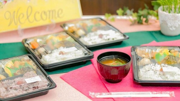 Una mesa con diferentes platos de comida y un tazón de sopa, probablemente en un restaurante o en una zona de comida.