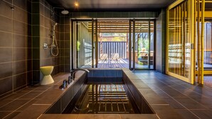 A modern bathroom with a large bathtub, a shower, and a glass-enclosed outdoor area with seating. - Kinnotake Sengokuhara - Adult Only (Hakone)