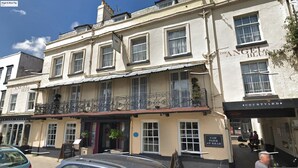 A building with multiple windows and a balcony with ornate metal railings. - Angel and Blue Pig (Lymington)