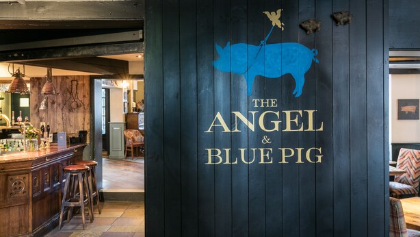 A bar area with stools and a wooden counter. - Angel and Blue Pig (Lymington)