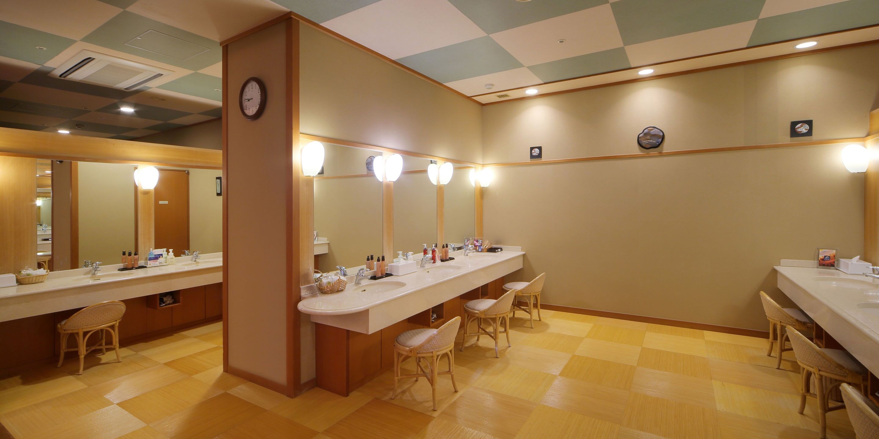 A public restroom with multiple sinks, mirrors, and seating areas.