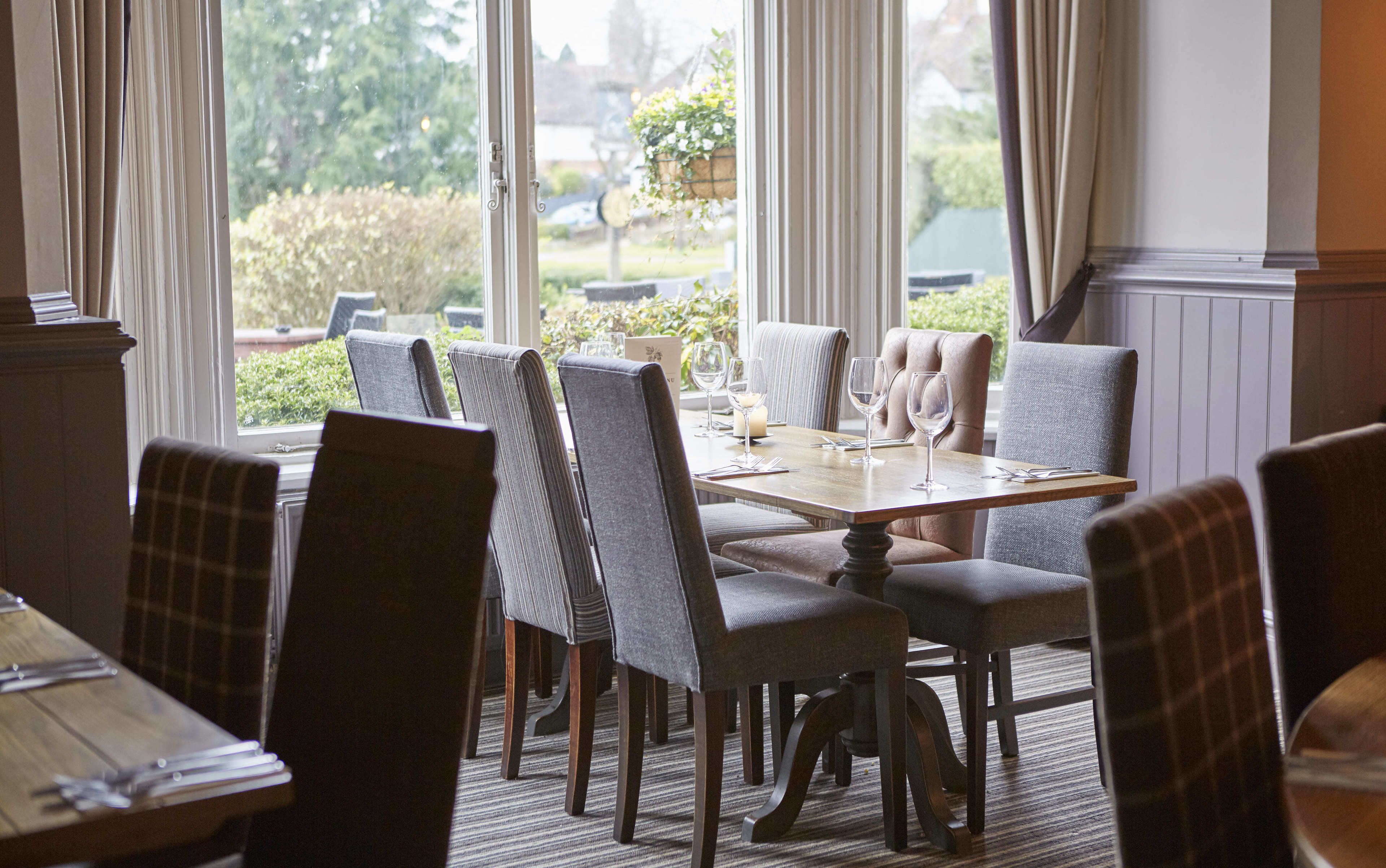Een eetruimte met een tafel voor vier personen, omringd door beklede stoelen.
