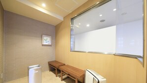 A conference room with a whiteboard, a wooden bench, and a white air conditioning unit. - Hotel Shinjukuya (Machida)