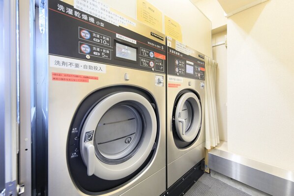 A row of industrial-style washing machines in a commercial setting.