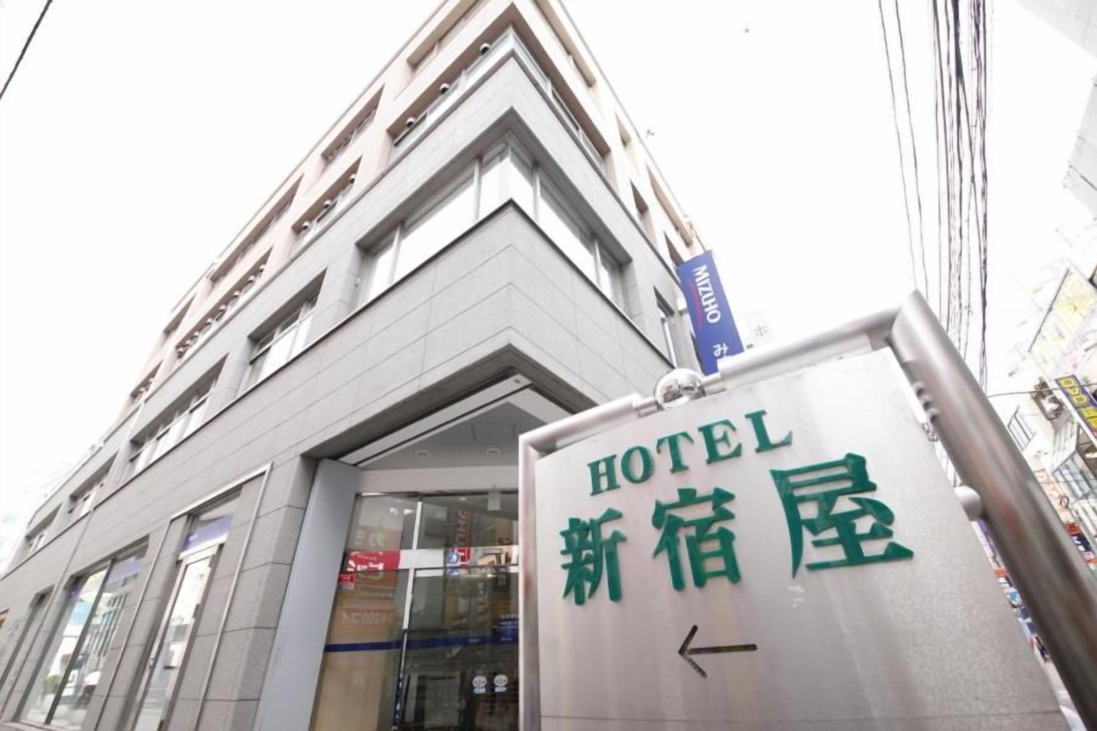 Señal de hotel con caracteres japoneses y una flecha direccional.