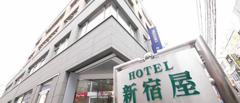 Señal de hotel con caracteres japoneses y una flecha direccional.