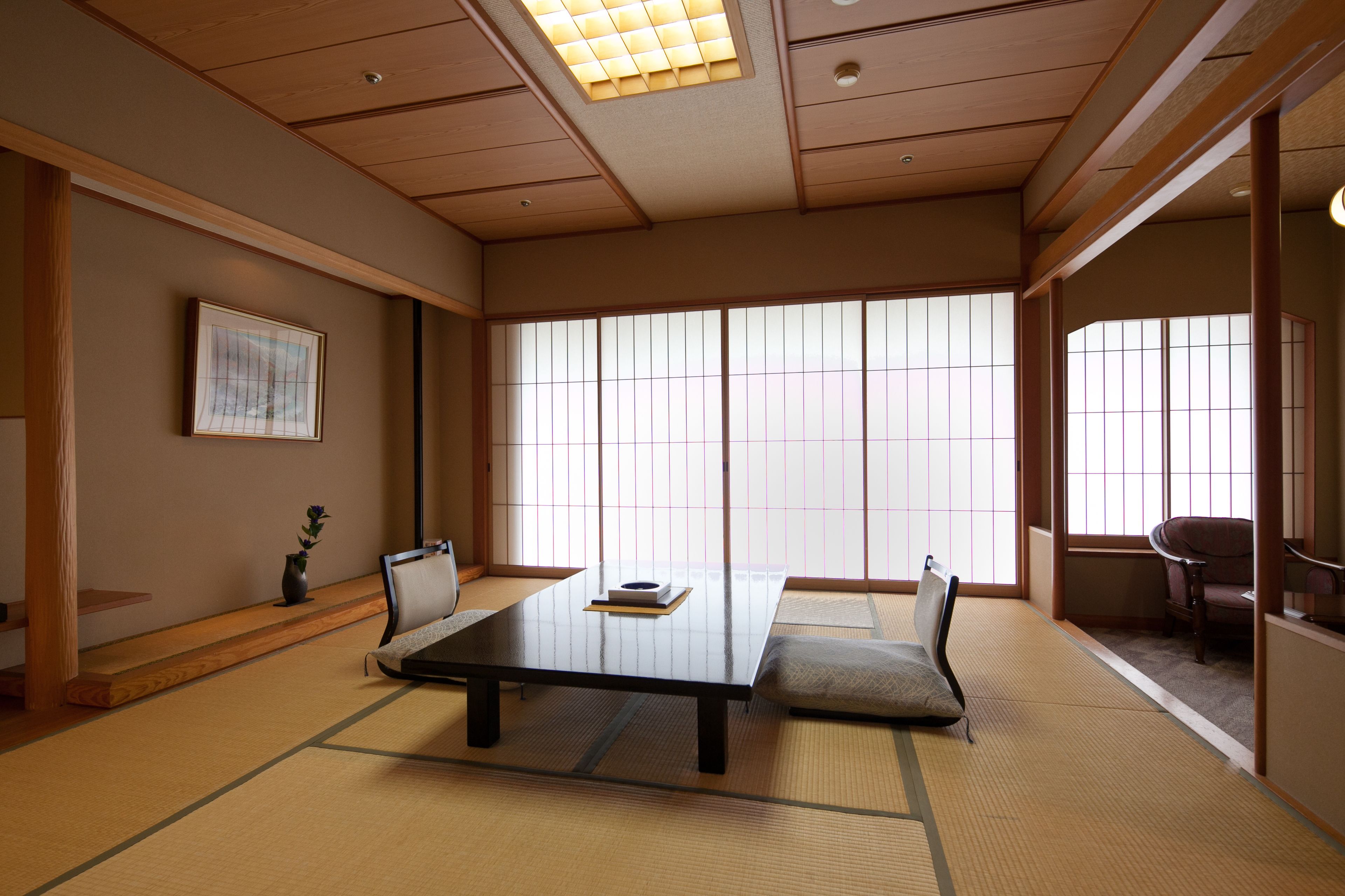 A traditional Japanese room with tatami flooring, a low table, and sliding doors.