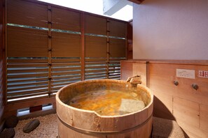A traditional wooden hot spring bath with a wooden partition and a stone basin. - Zazan Minakami (Minakami)