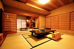 A traditional Japanese room with tatami flooring, a low table, and sliding doors. - Zazan Minakami (Minakami)