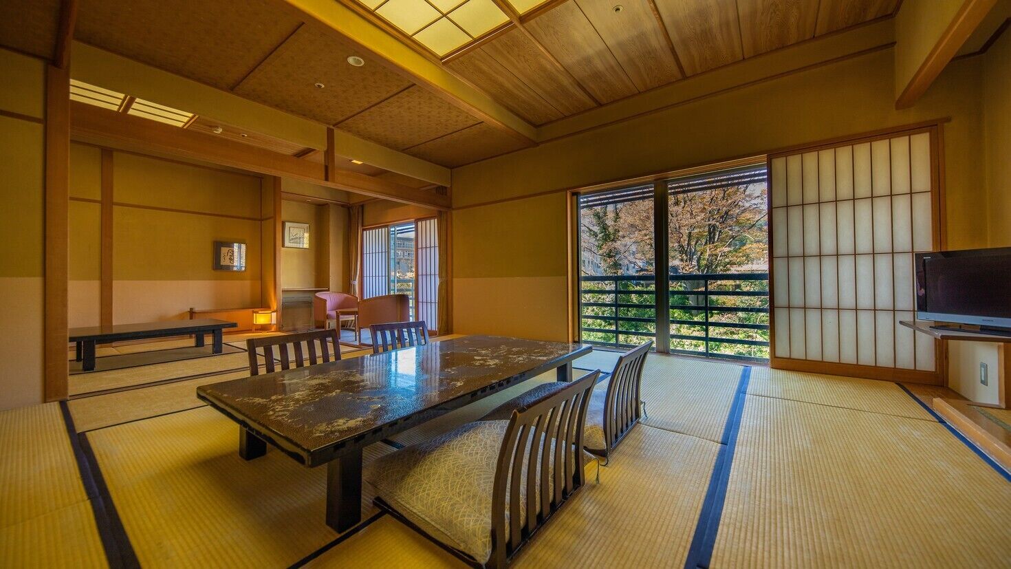 A traditional Japanese room with tatami flooring, a low table, and sliding doors.