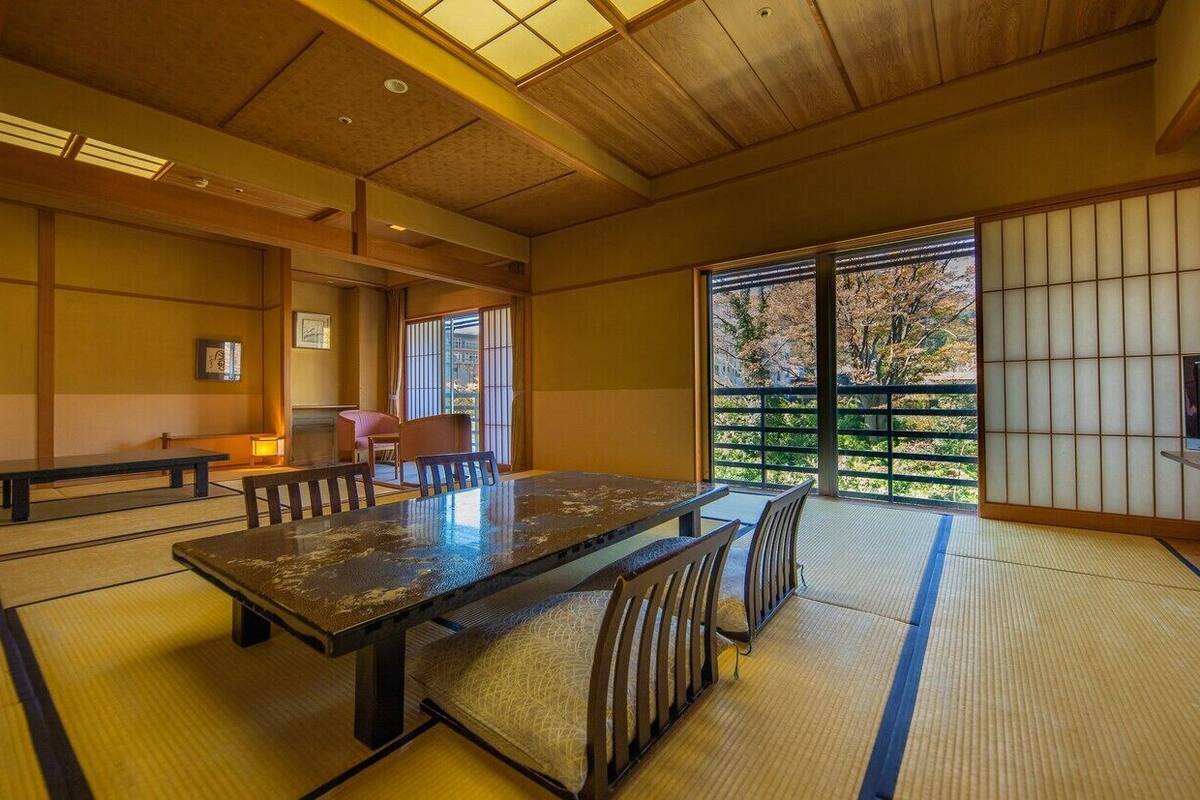 A traditional Japanese room with tatami flooring, a low table, and sliding doors.