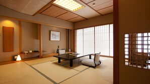 A tatami mat room with a low table, chairs, a lamp, and a large window. - Zazan Minakami (Minakami)
