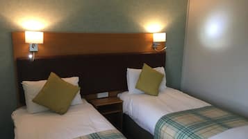 A twin room with two beds, each with a headboard and bedside lamps.