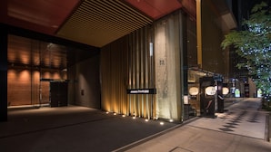A modern building facade with vertical wooden slats and illuminated signage.