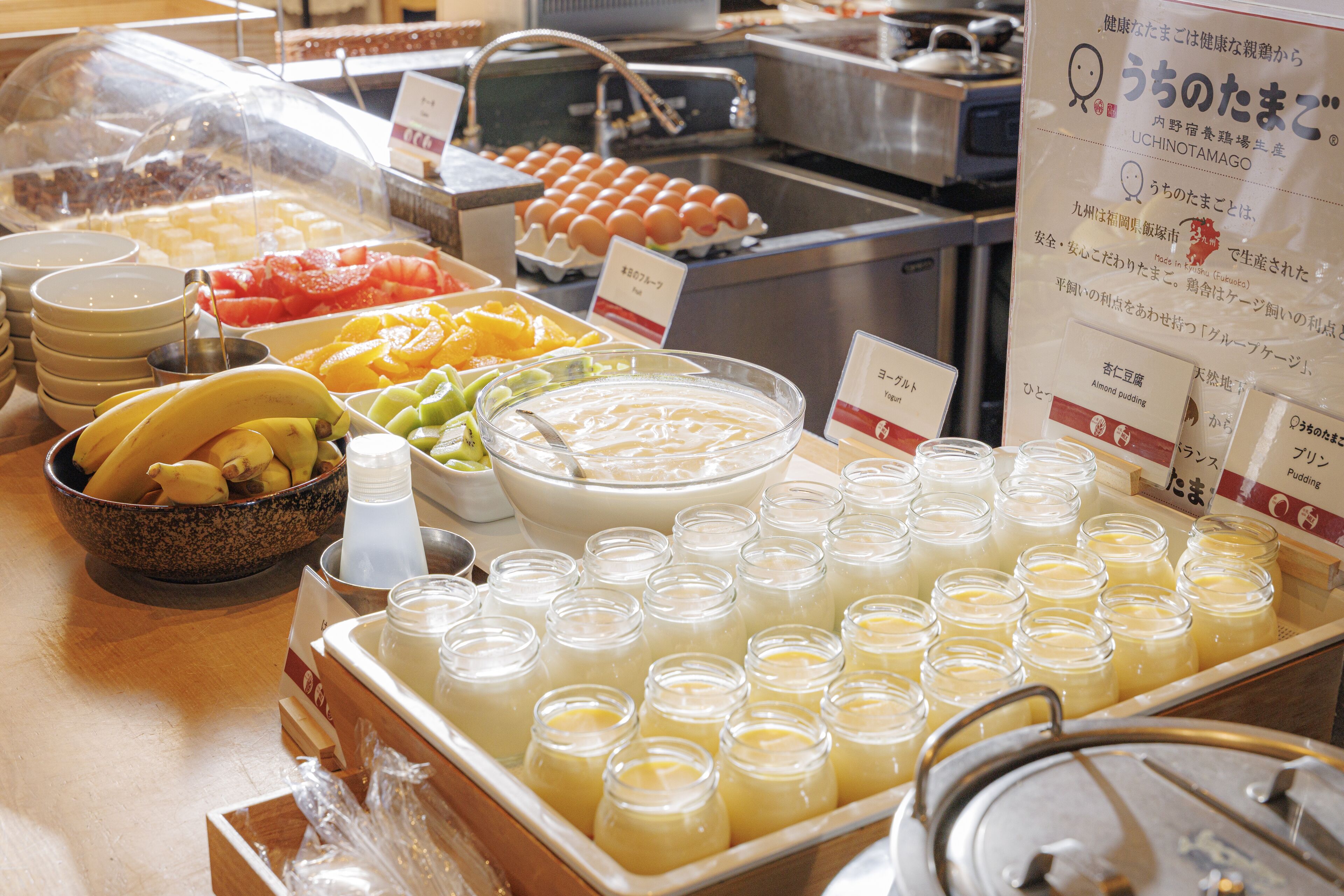 Un buffet con diverse pietanze, tra cui frutta, verdura e una grande ciotola di zuppa.