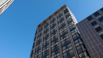 A tall, modern building with a grid of windows and a flat roof.