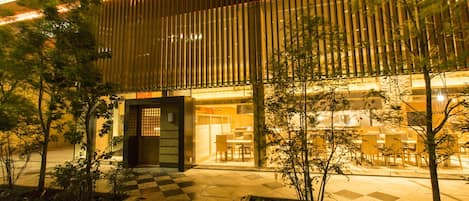 A modern building with a checkered floor pattern, vertical wooden slats, and a glass entrance.