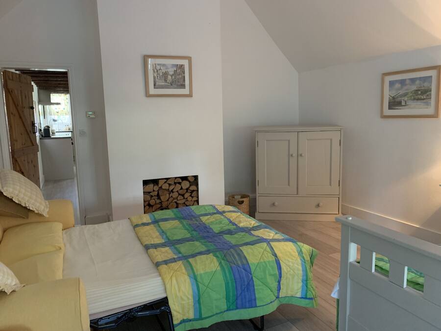 A bedroom with a bed, a wardrobe, and two framed pictures on the wall.