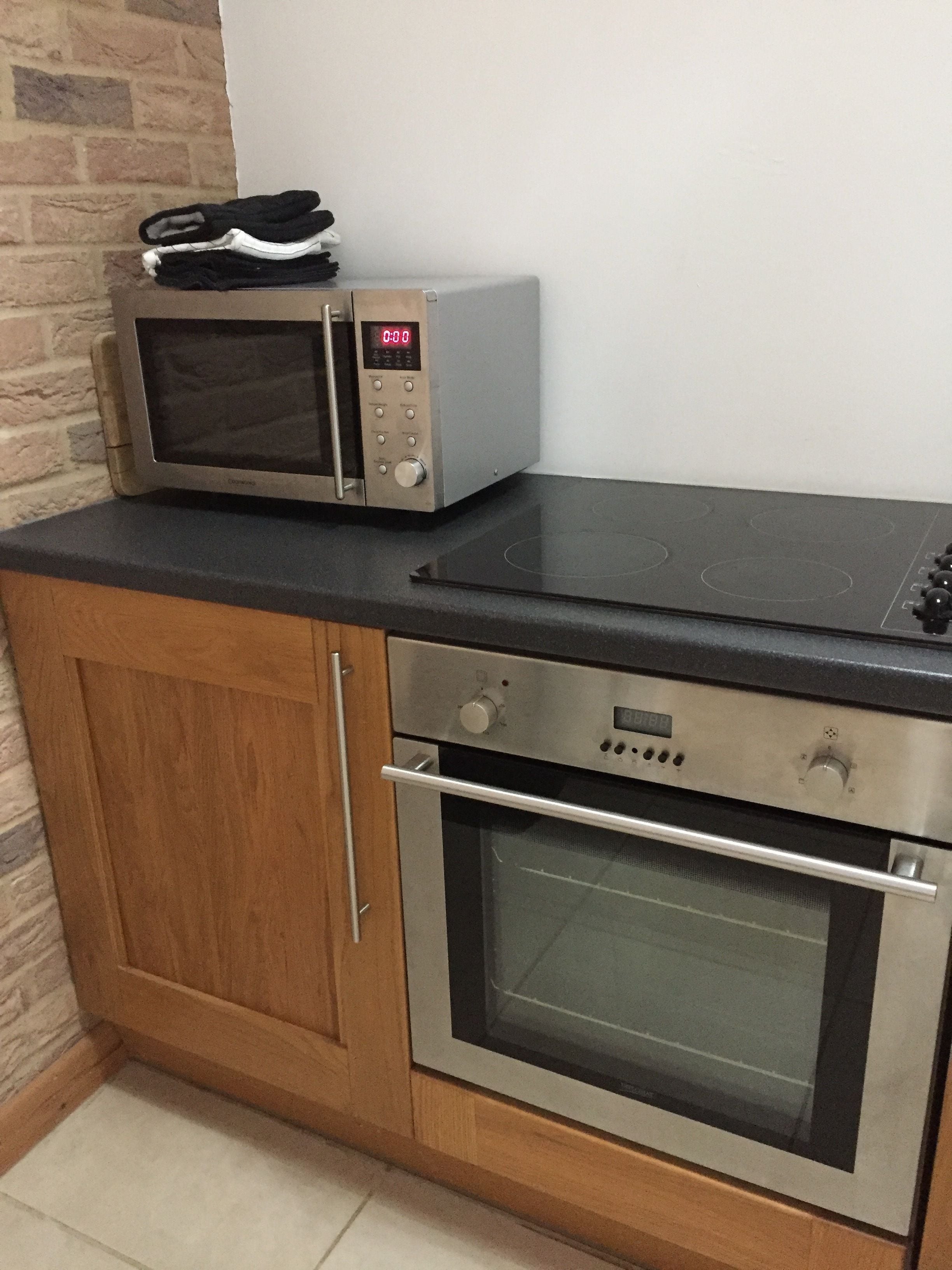 Una cocina equipada con microondas, horno y estufa.